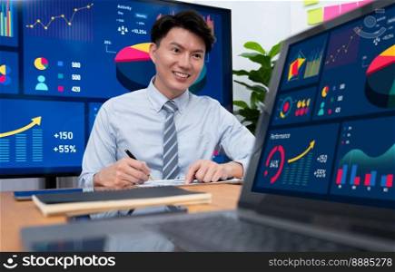 Portrait of successful confident businessman, manager or executive in business wear analyzing financial report with dashboard data on TV screen in the background at harmony office meeting room.. Portrait of male manager in harmony office with businesspeople in background.