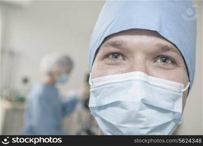 Portrait of surgeon with surgical mask and surgical cap in the operating room