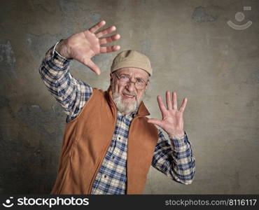 portrait of surprised and scared senior, bearded man trying to protect himself with hands