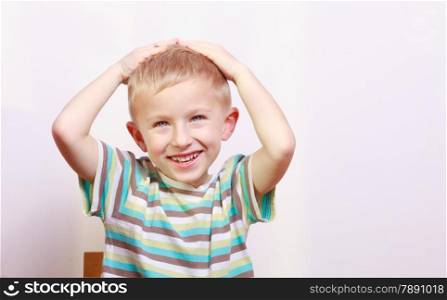 Portrait of surprised excited emotional blond boy child kid at the table interior. Emotions.
