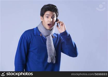 Portrait of surprised man having conversation on mobile phone
