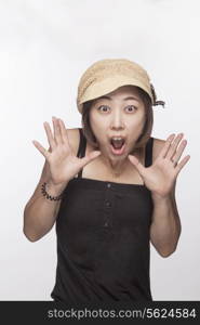 Portrait of surprised woman with hands raised, studio shot