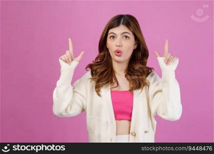 Portrait of Surprised young woman pointing to empty copy space for product over isolated pink background. Advertisement concept.