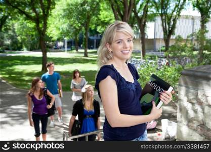 Portrait of sweet young girl going to college with friends in background
