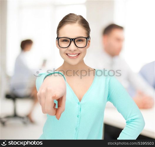 portrait of sweet young girl in glasses pointing at you