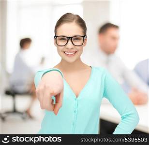 portrait of sweet young girl in glasses pointing at you