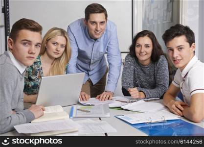 Portrait Of Teacher And Pupils Working In Classroom Together