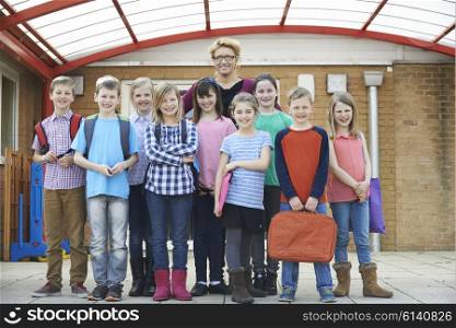 Portrait Of Teacher With Pupils In Playground