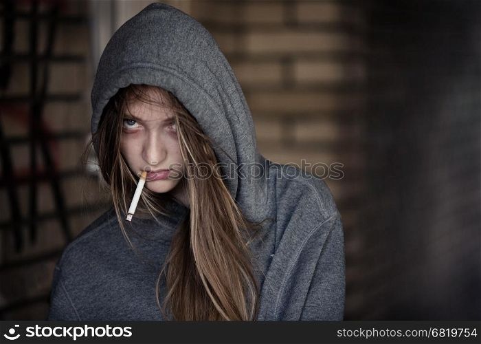 Portrait of Teen Girl in Hood Smoking a Cigarette