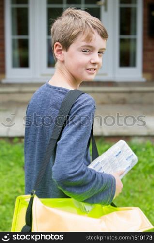 Portrait Of Teenage Boy Delivering Newspaper To House