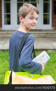 Portrait Of Teenage Boy Delivering Newspaper To House