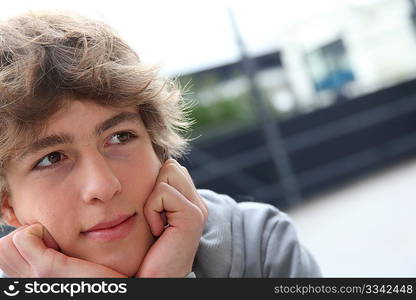 Portrait of teenage boy in front of school building