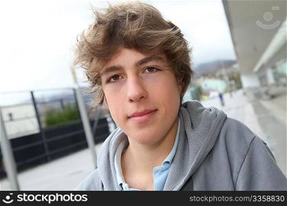 Portrait of teenage boy in front of school building