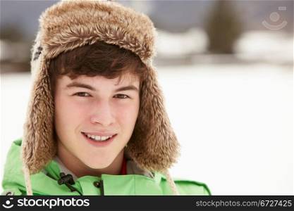 Portrait Of Teenage Boy In Snow Wearing Fur Hat
