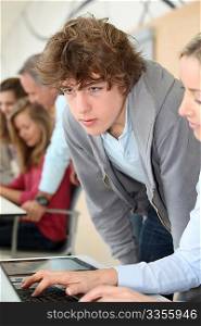 Portrait of teenage boy looking at computer in class
