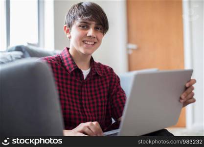 Portrait Of Teenage Boy Working On Laptop At Home
