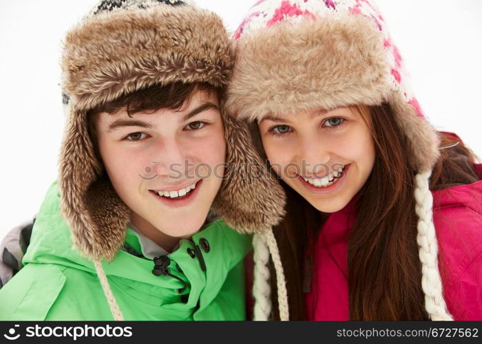 Portrait Of Teenage Couple In Snow Wearing Fur Hats