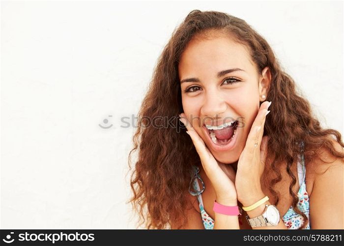 Portrait Of Teenage Girl Leaning Against Wall Making Face
