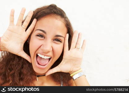 Portrait Of Teenage Girl Leaning Against Wall Making Face