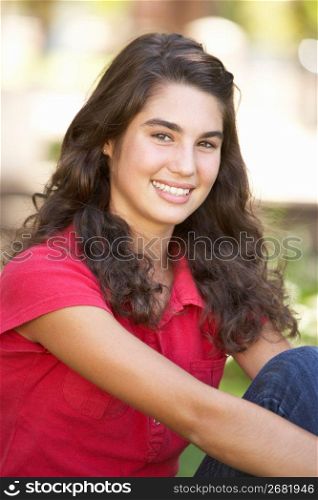 Portrait Of Teenage Girl Sitting In Park