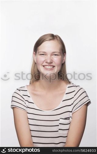Portrait of teenage girl with blond hair smiling, studio shot