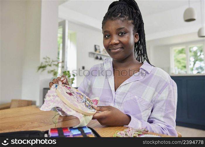 Portrait Of Teenage Girl Working On Embroidery Design On Table At Home