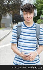 Portrait Of Teenage Student Outside College Building Listening To Music