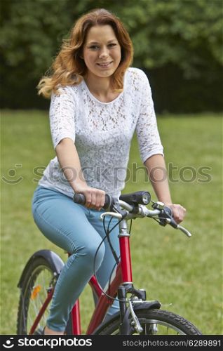 Portrait Of Teenager Girl Riding Bike In Countryside