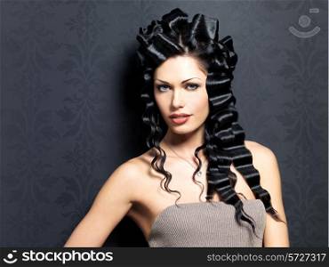 Portrait of the beautiful fashion sexy woman with long curly hairstyle poses indoor