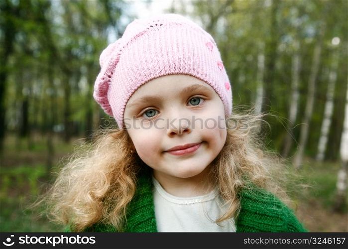 Portrait of the beautiful little girl with long hair in forest