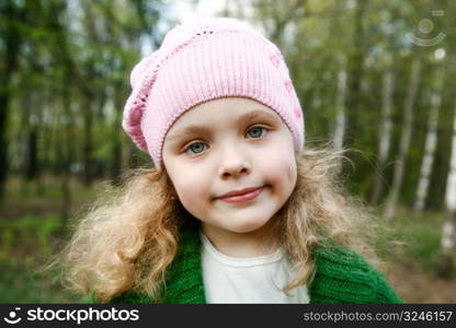 Portrait of the beautiful little girl with long hair in forest