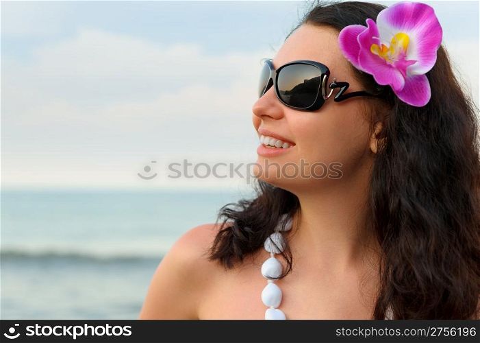 Portrait of the beautiful woman on seacoast. A profile, sun glasses