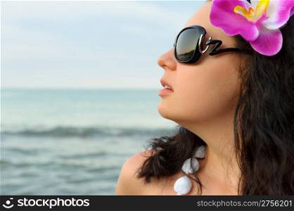 Portrait of the beautiful woman on seacoast. A profile, sun glasses
