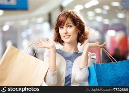 Portrait of the beautiful woman with bags in shop