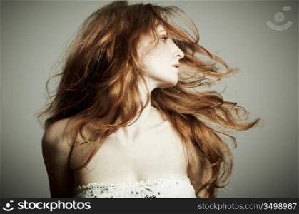 Portrait of the beautiful woman with red curly hair