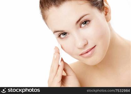 Portrait of the beautiful young girl applying on a face a cosmetic pad, isolated