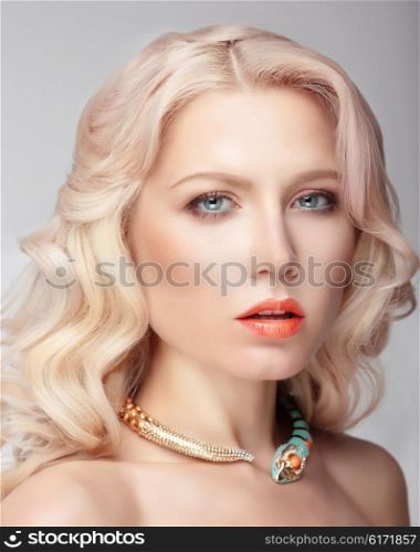Portrait of the blonde with blue eyes and natural makeup, decoration on neck.