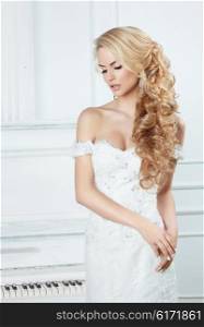 Portrait of the bride with long locks. In a white dress.