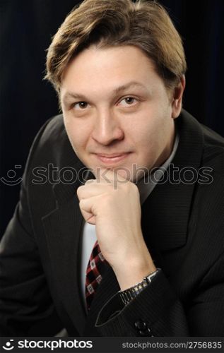 Portrait of the businessman on a dark background. The European nationality
