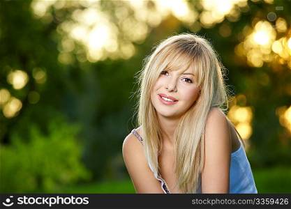 Portrait of the charming blonde in a summer garden