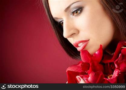 Portrait of the charming girl with the red petals, isolated