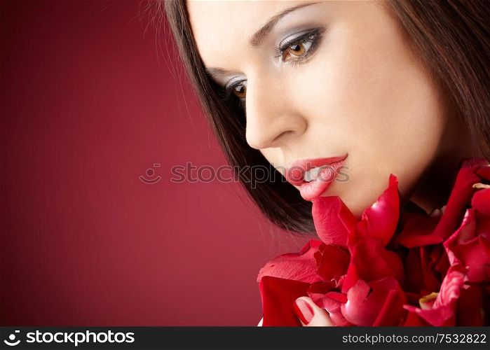 Portrait of the charming girl with the red petals, isolated