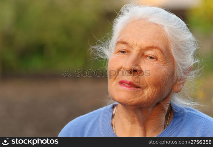 Portrait of the elderly woman. A photo on outdoors