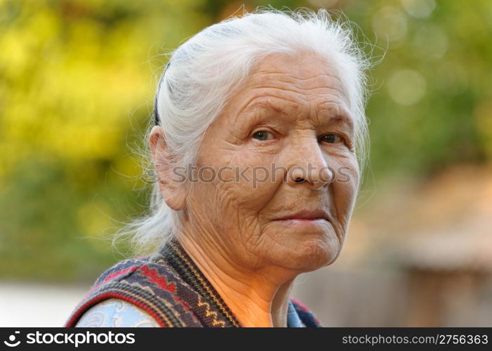 Portrait of the elderly woman. A photo on outdoors