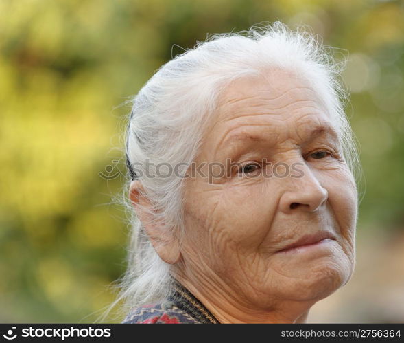 Portrait of the elderly woman. A photo on outdoors