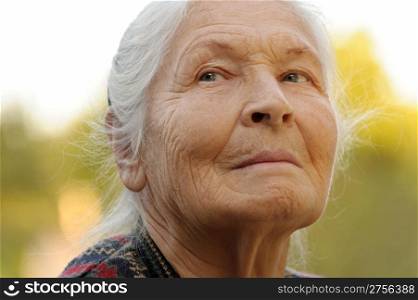 Portrait of the elderly woman. A photo on outdoors