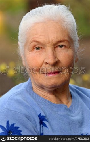 Portrait of the elderly woman. A photo on outdoors