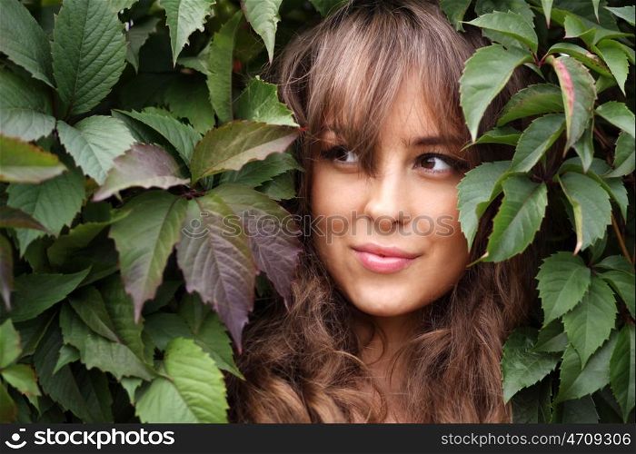 Portrait of the girl in green foliage