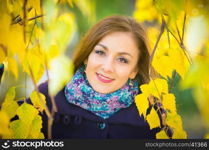 Portrait of the girl in the yellow foliage of trees