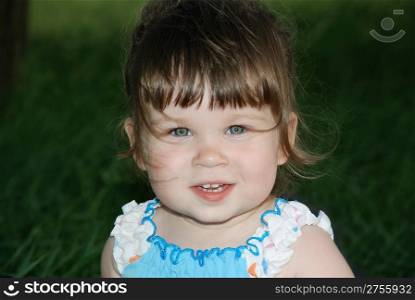 Portrait of the little girl with hair developing on a wind